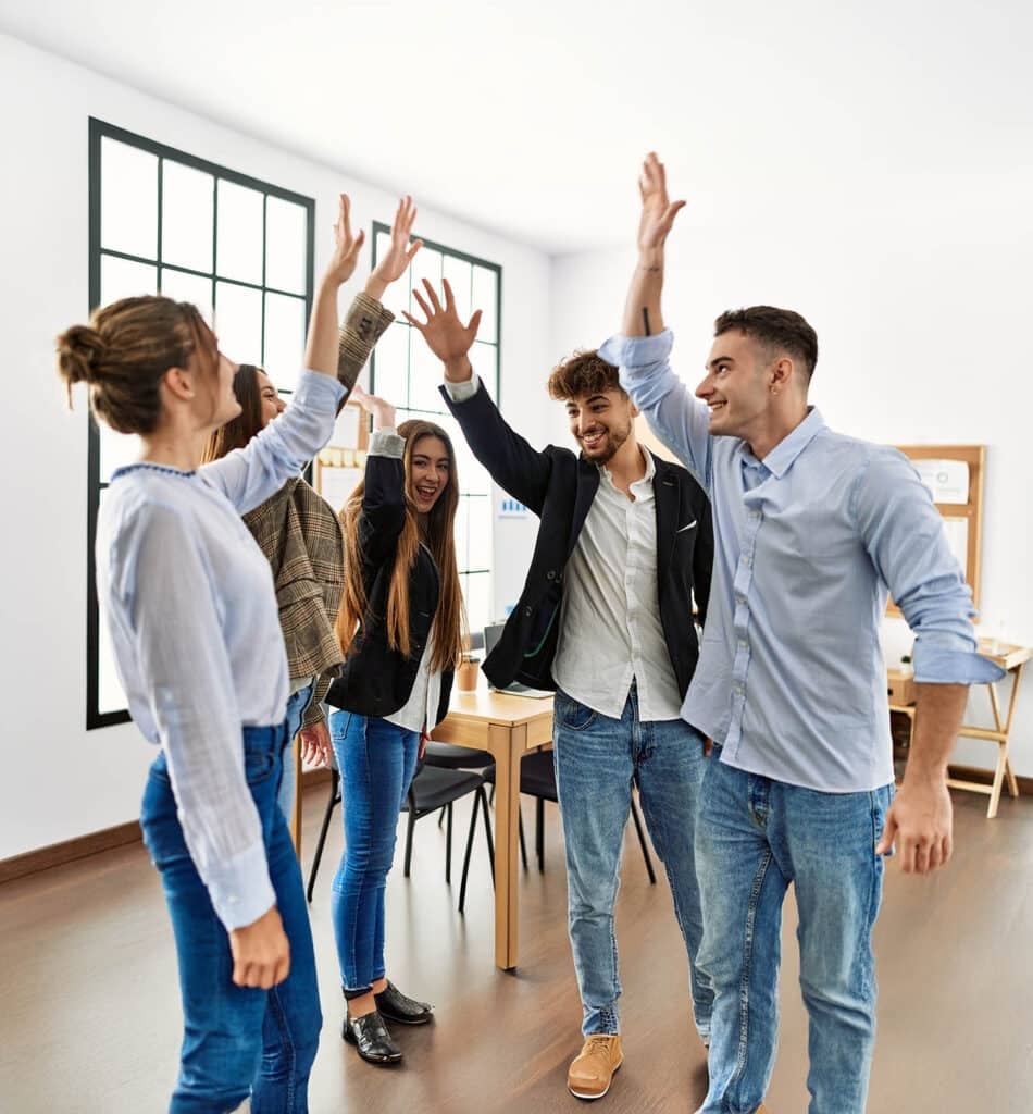 Group of business workers smiling happy standing with hands raised up at the office.